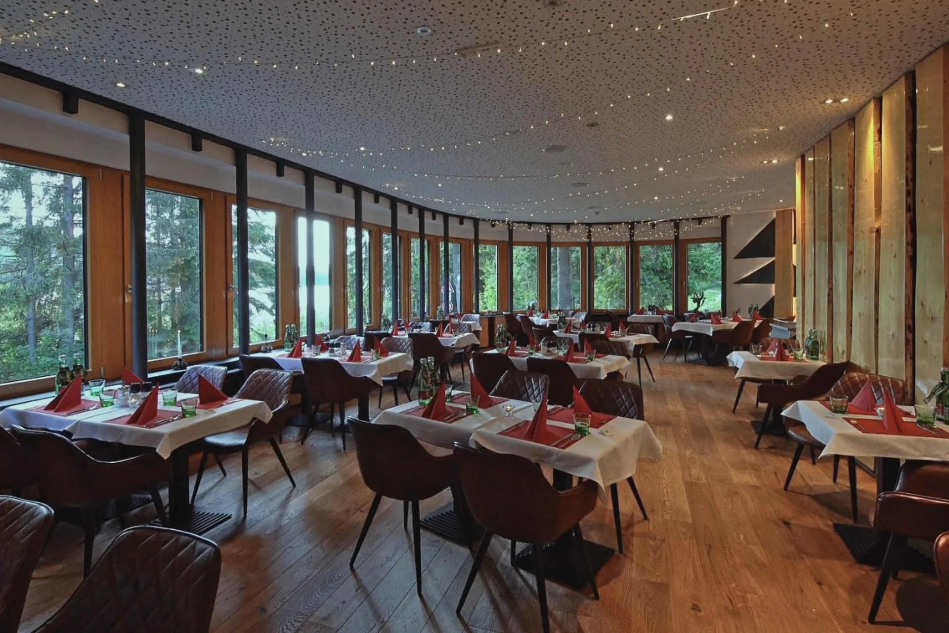 Interiér restaurace hotelu Montanie s výhledem do přírody Jizerských hor