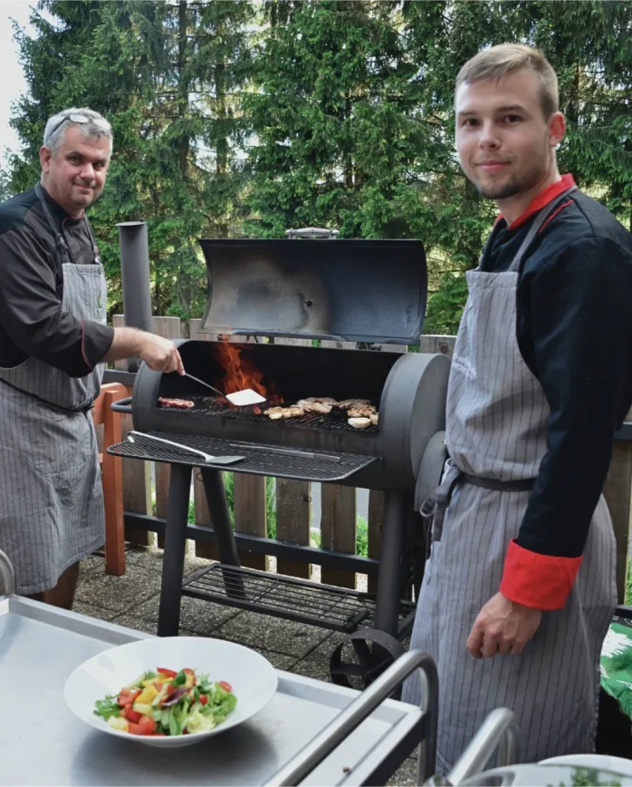 Kuchaři Montanie Resort připravují grilované speciality na venkovní terase obklopené smrkovými lesy Jizerských hor.